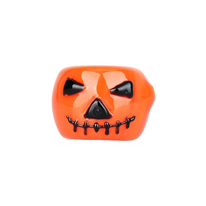 Close-up of the jack-o-lantern face design on the Pumpkin Halloween Glass Hand Pipe.