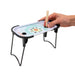 A hand holding a wooden stick over a small tabletop game tray with a colorful printed center and black metal legs, shown on a clean white background.