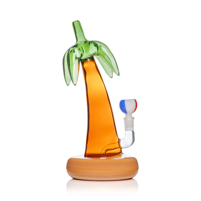 Palm tree-shaped glass bottle with wooden base on a white background