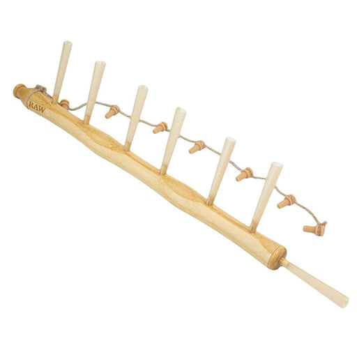 Wooden rolling pin with attached skewers on a white background